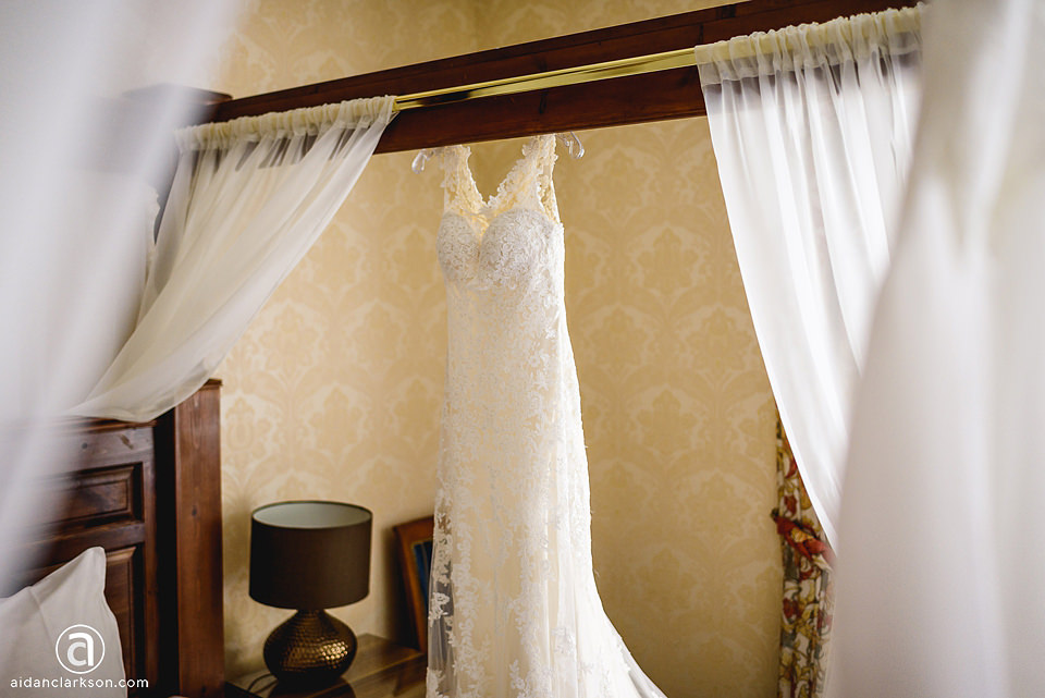 A wedding dress hanging in the elegant bedroom of Kenwick Park.