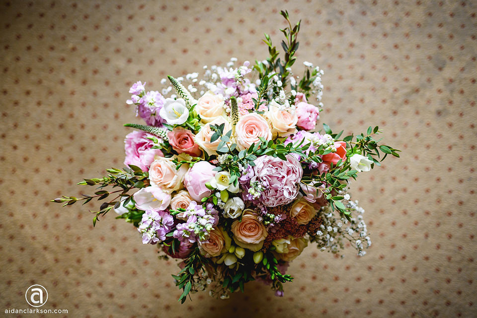 A wedding bouquet of flowers sitting on a polka dot background.