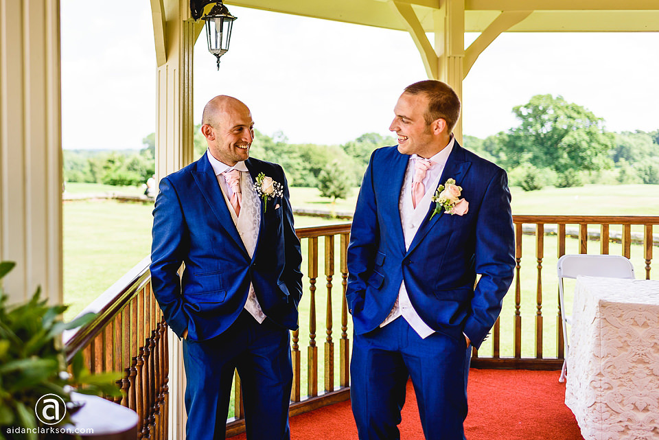 Two grooms standing in front of a wedding gazebo at Kenwick Park.