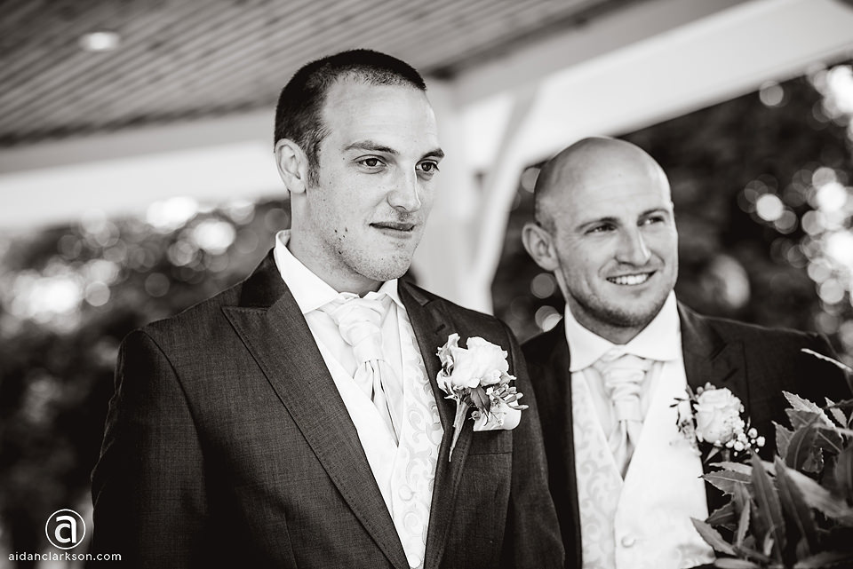 Two grooms standing next to each other in a black and white wedding photo at Kenwick Park.