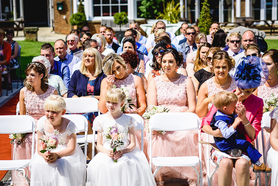 A beautiful wedding ceremony at Kenwick Park, with many people sitting in chairs.