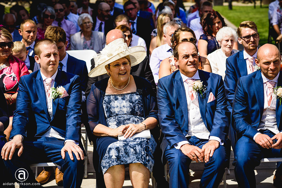 A group of people sitting at a wedding ceremony at Kenwick Park.