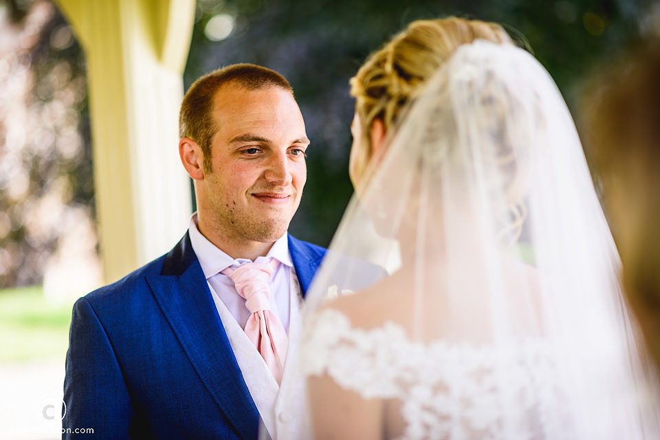 A bride and groom look at each other during their Kenwick Park wedding ceremony.
