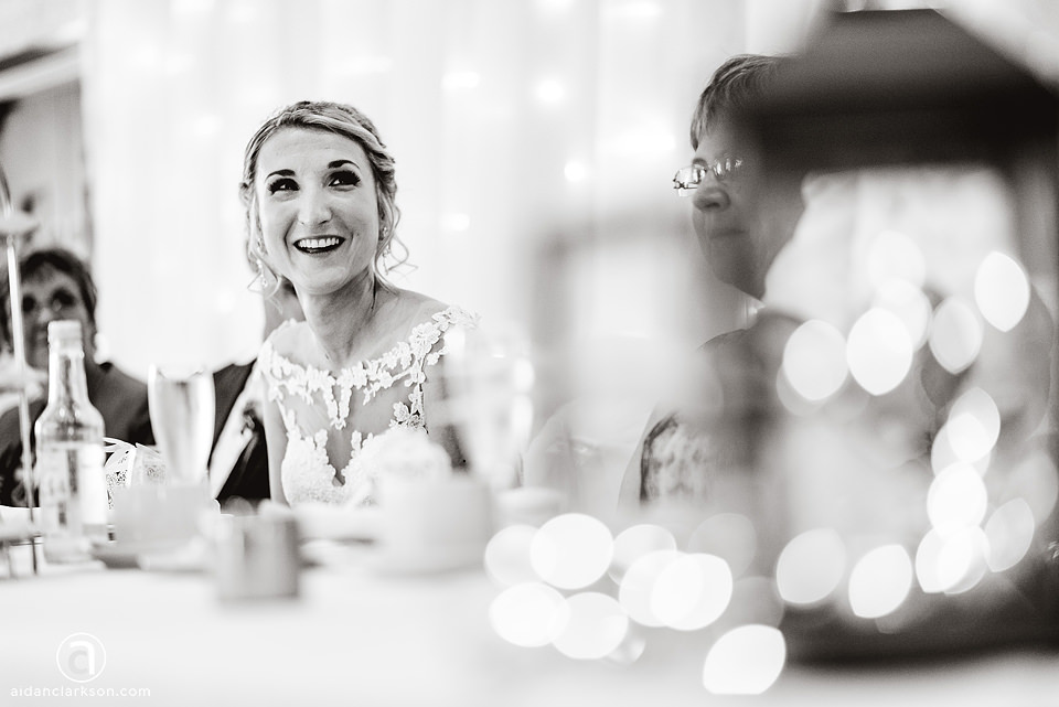 Black and white photo of a bride laughing at her wedding reception at Kenwick Park.