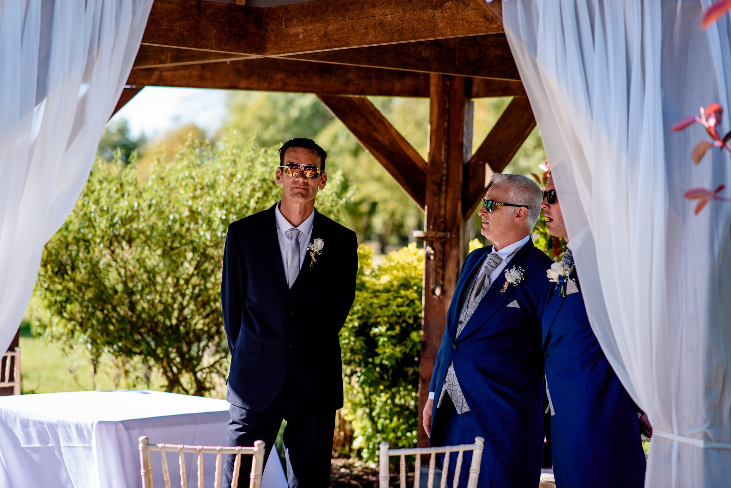 A groom standing in front of Laceby Manor wedding gazebo.