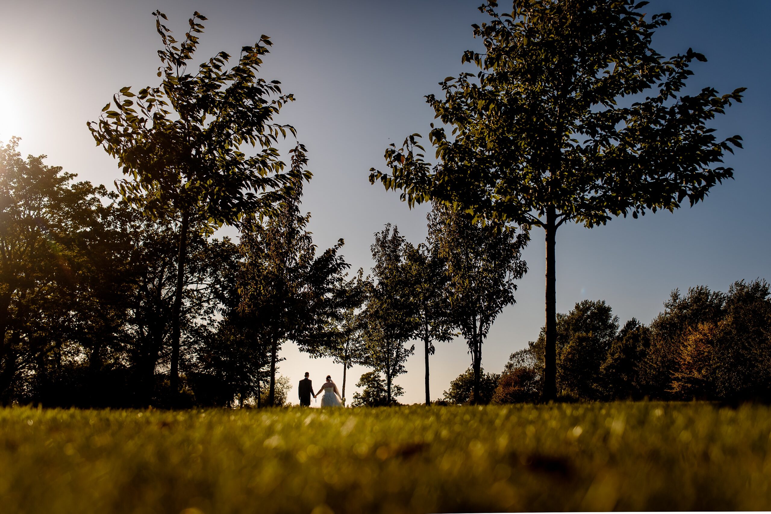 A couple strolling through Laceby Manor, with trees in the background.