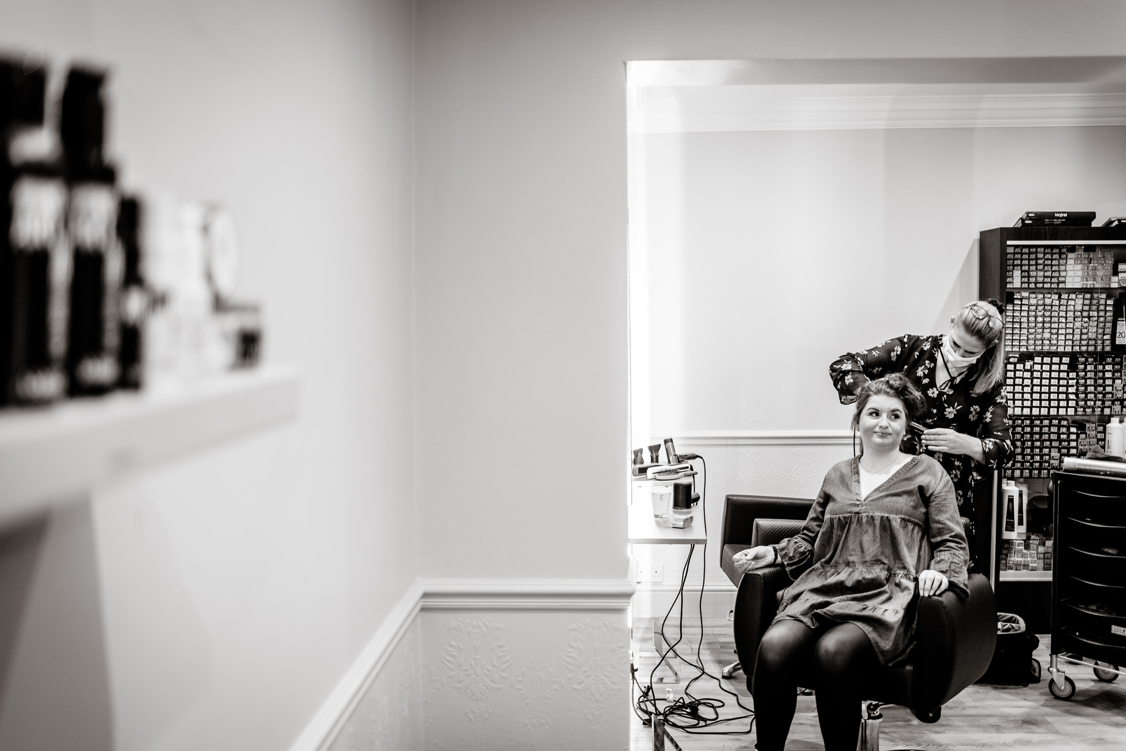 A woman getting her hair done in a salon for a brackenborough hotel wedding.