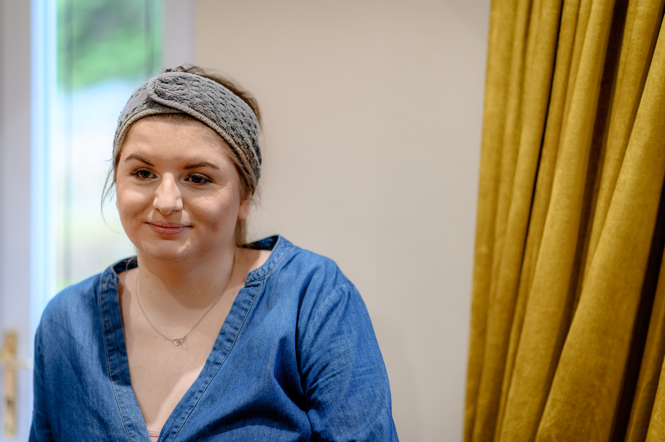 A woman wearing a blue shirt and a headband at the Brackenborough Hotel wedding.