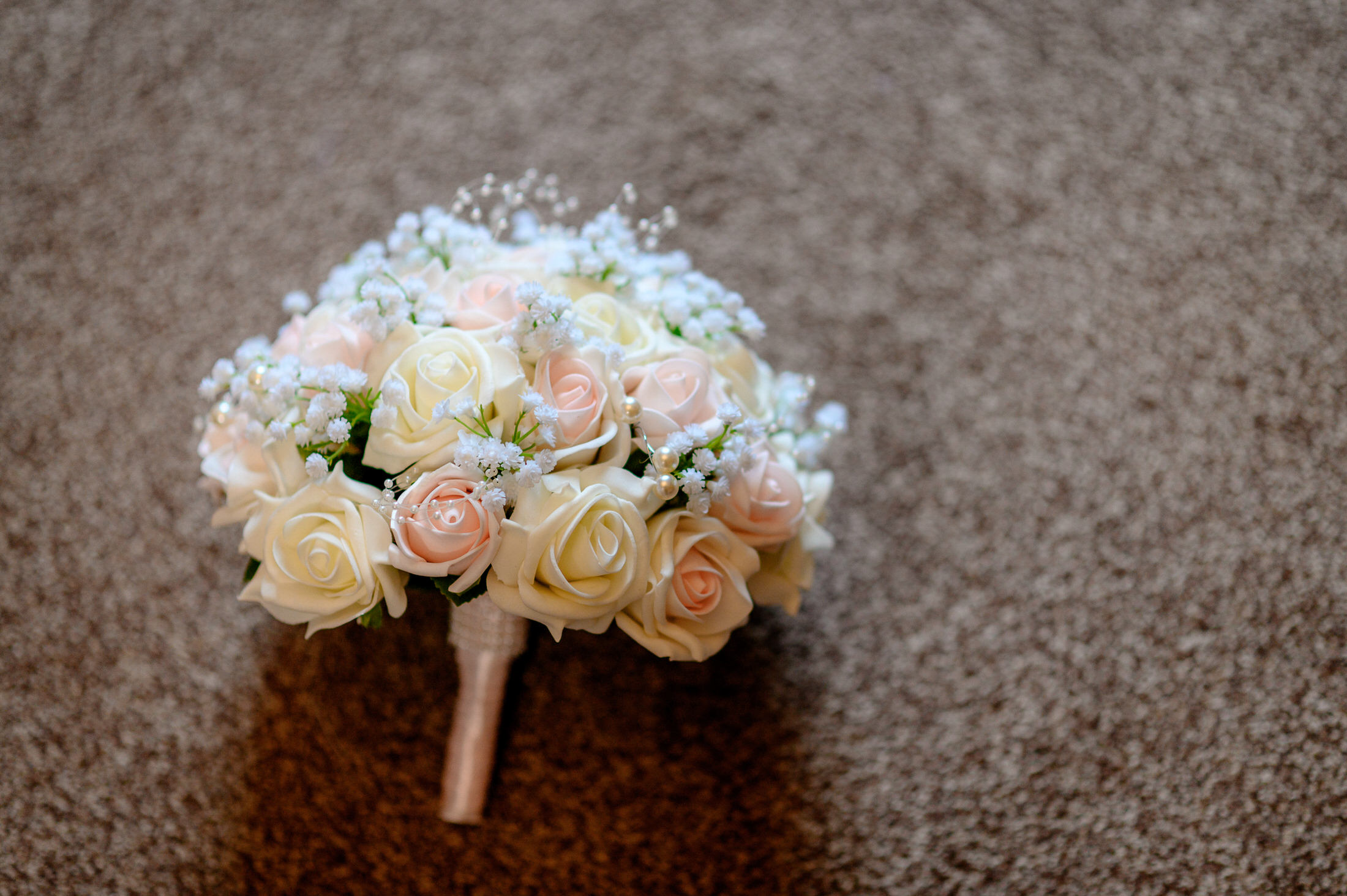 A bouquet of white and pink roses at a wedding ceremony held at Brackenborough Hotel.