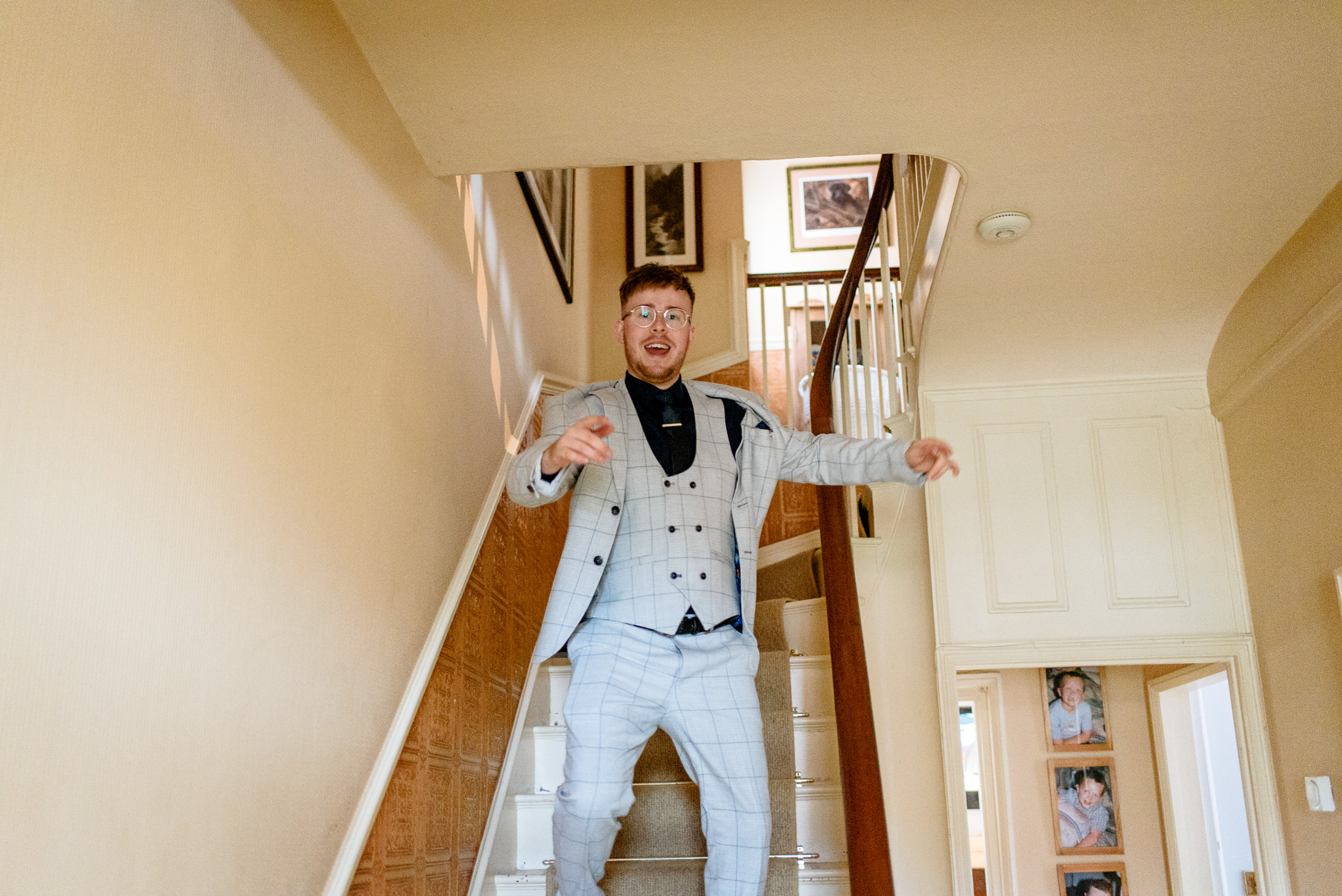 A man in a suit standing on a staircase at a wedding.