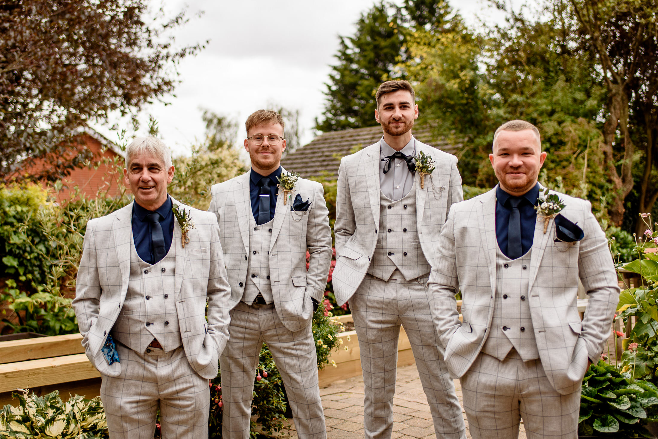 A group of groomsmen posing for a photo at a wedding.