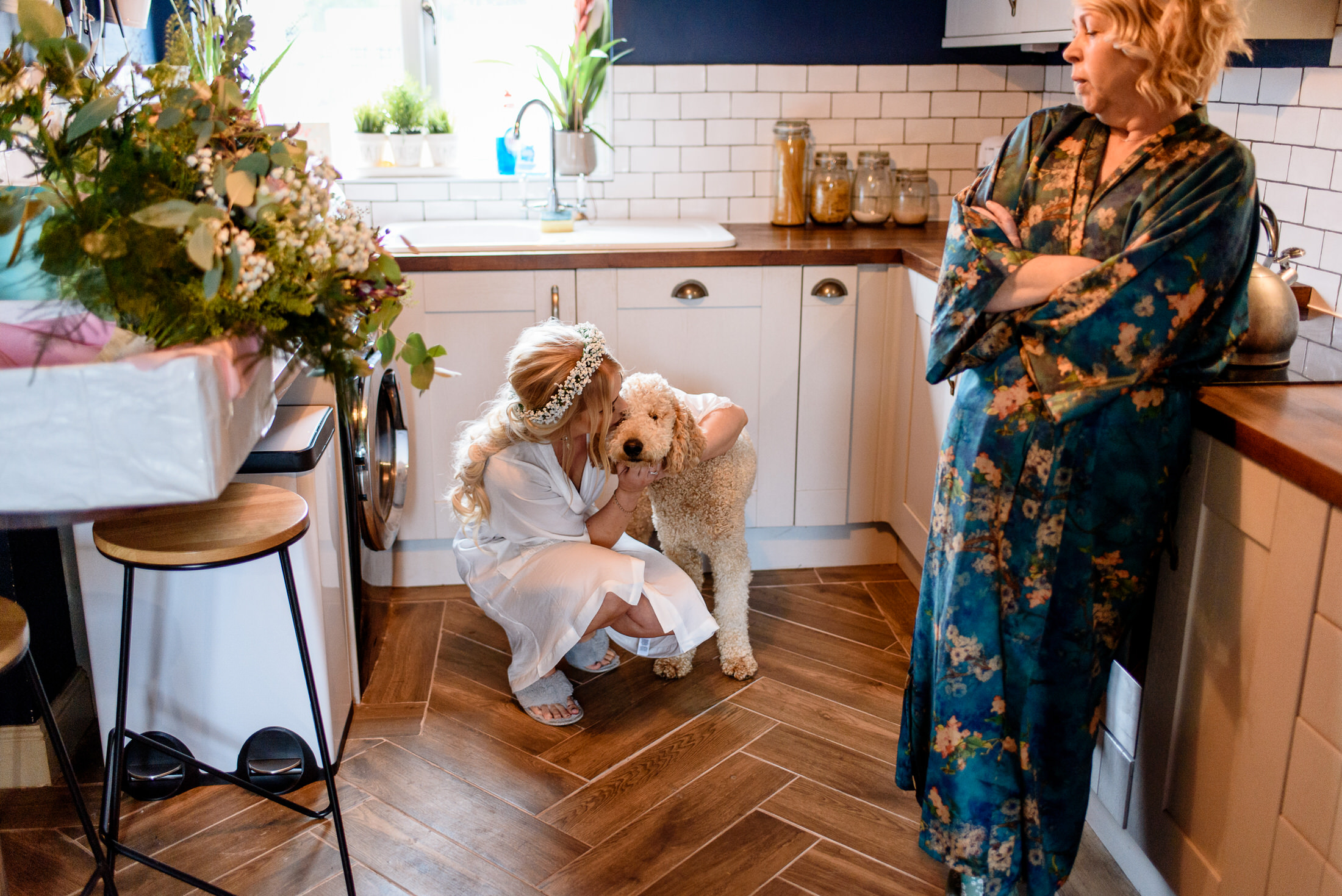 A woman in a robe is petting a dog in a scrivelsby walled garden.