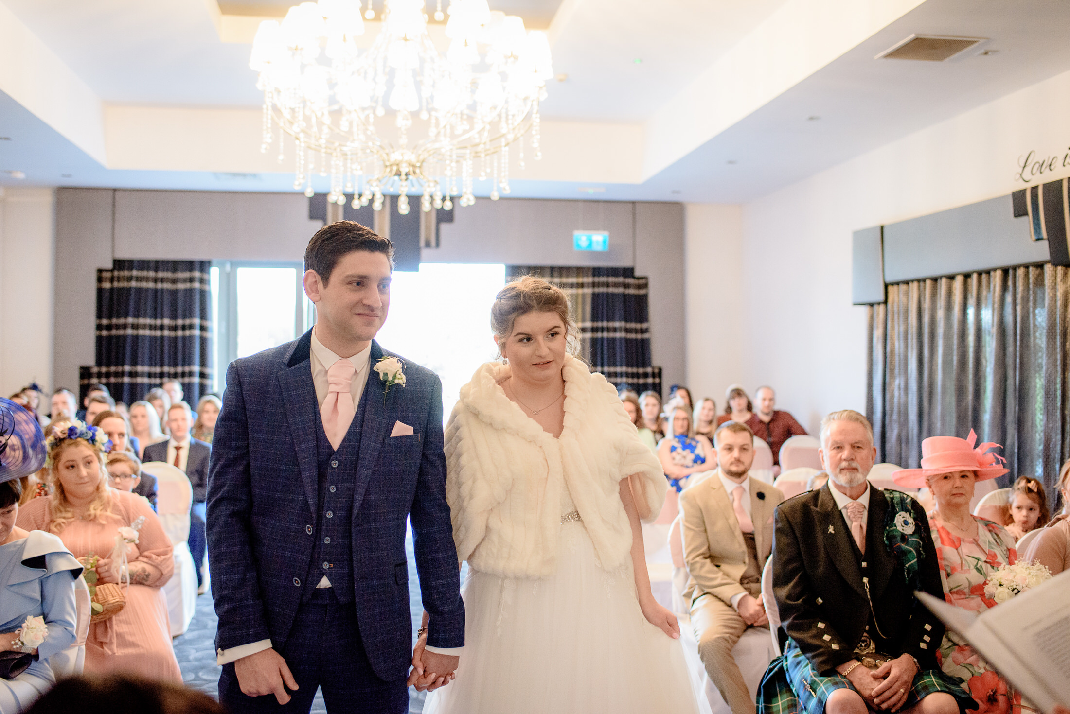 A bride and groom walking down the aisle at a Brackenborough Hotel wedding ceremony.