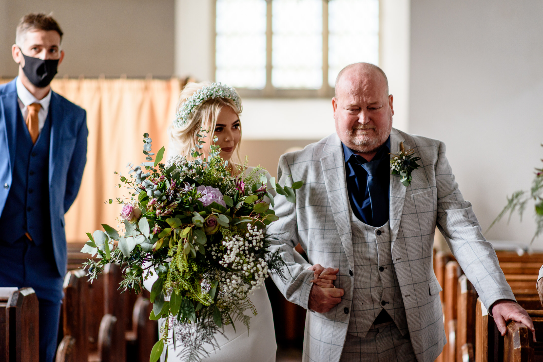 A wedding couple gracefully walking down the aisle in a church.