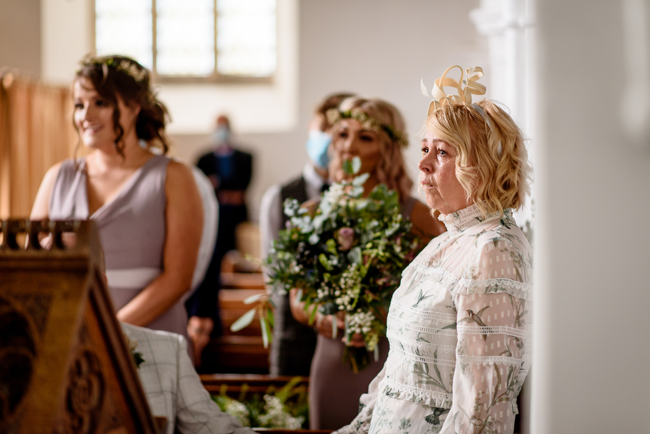 At a wedding in Scrivelsby Walled Garden, a bride and groom share an intimate moment as they gaze lovingly into each other's eyes inside the church.