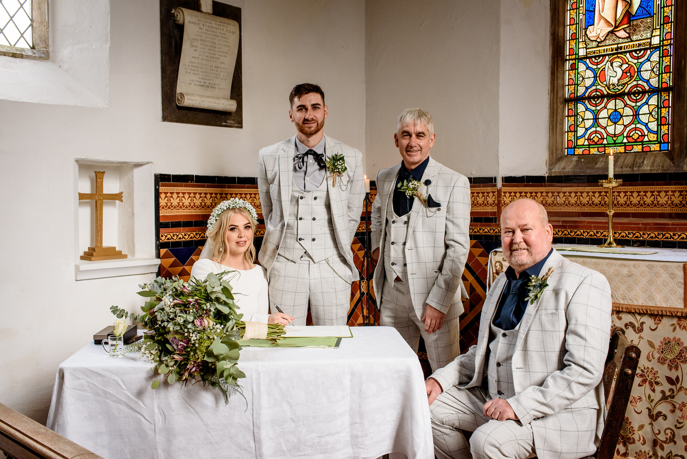 A scrivelsby walled garden wedding party poses for a picture in a church.
