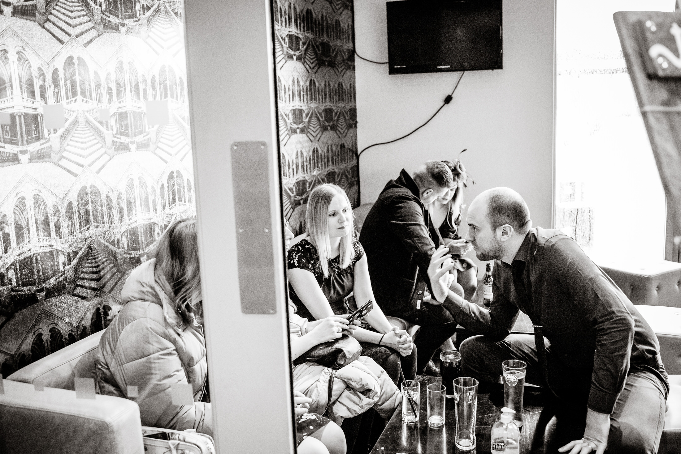 A black and white photo of people sitting in a room at the Brackenborough Hotel wedding.