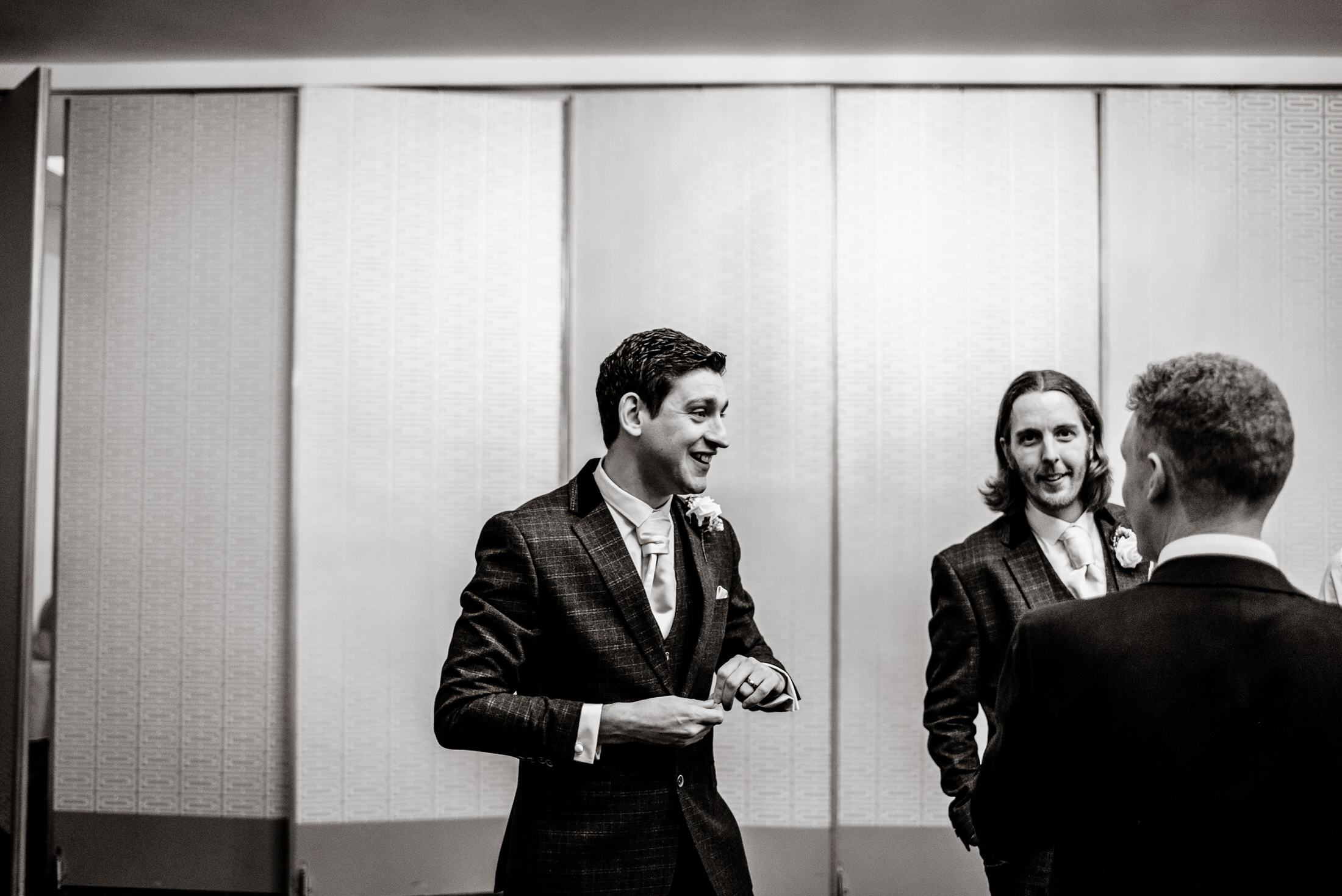 A black and white photo capturing the groom and his groomsmen at a Brackenborough Hotel wedding.