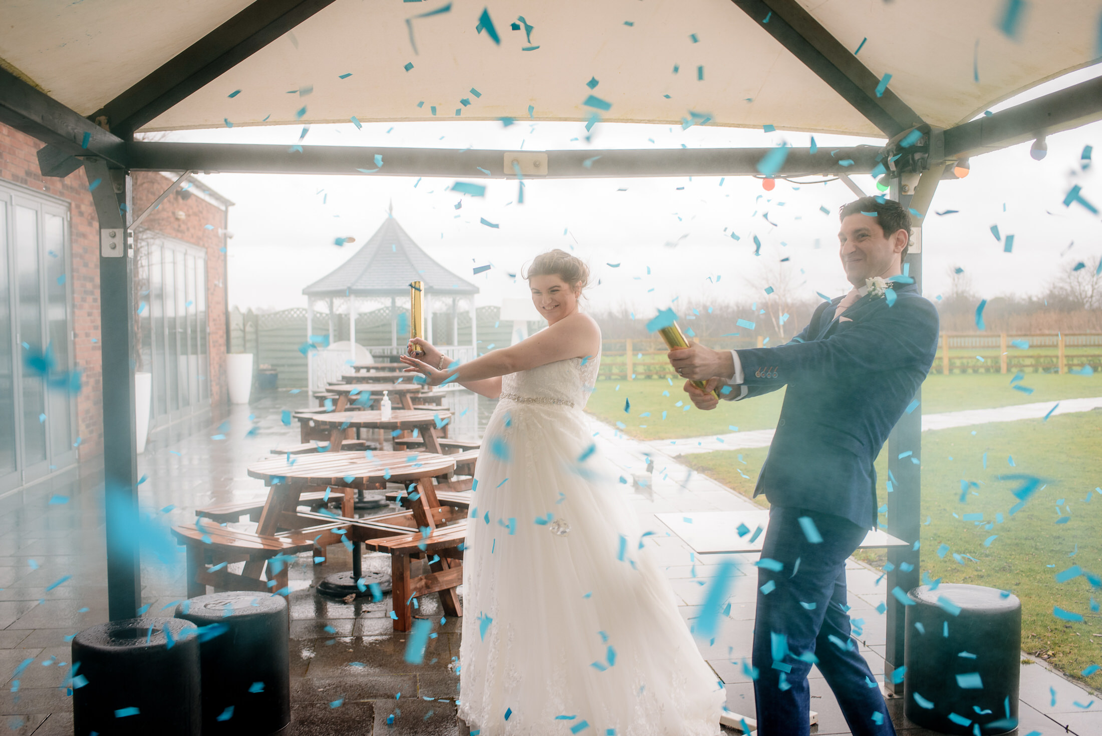 A bride and groom exchanging confetti at their elegant Brackenborough Hotel wedding.