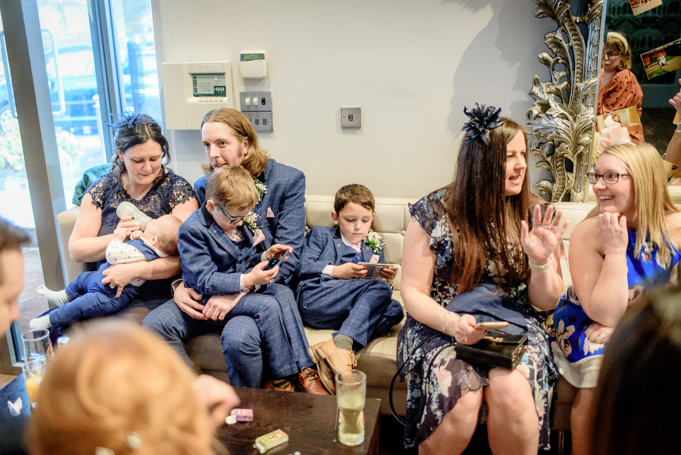 A group of people sitting on a couch watching tv at Brackenborough Hotel.