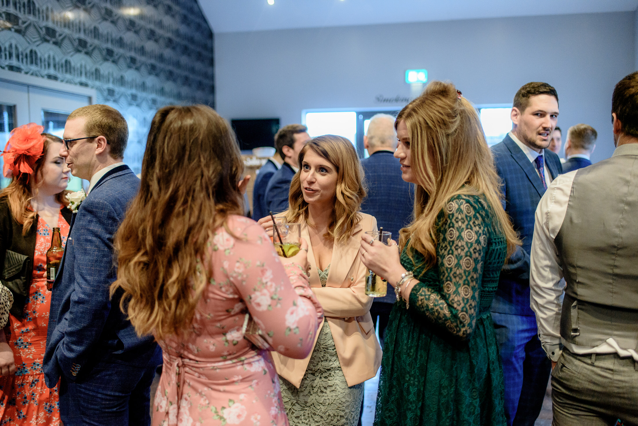 A group of people talking at a Brackenborough Hotel wedding party.