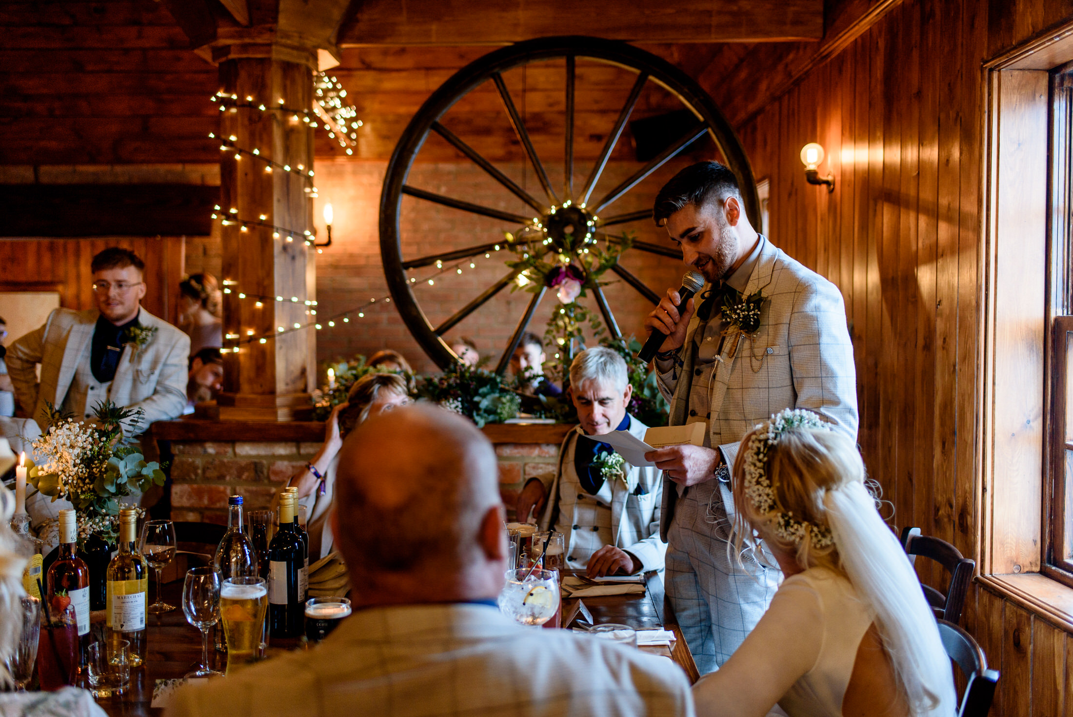 A wedding couple is seated at a table in Scrivelsby Walled Garden, a charming barn venue.