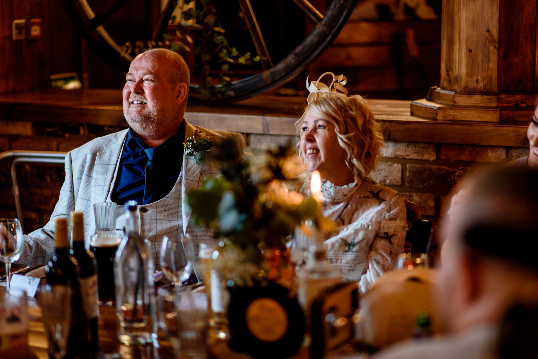 A group of people sitting at a table at the Scrivelsby Walled Garden, with a wheel in the background.