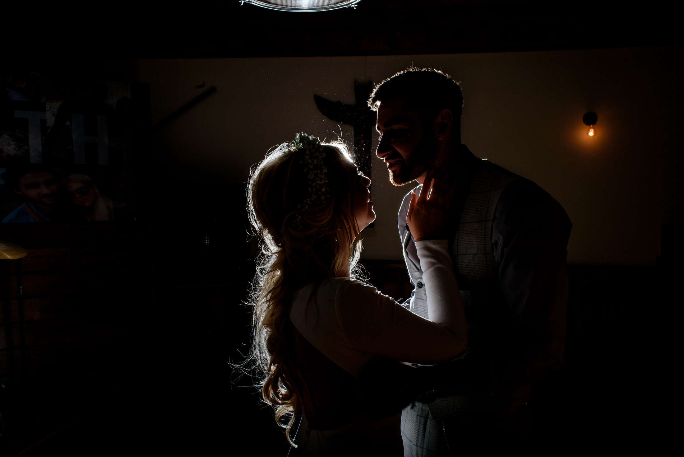 A silhouette of a man and woman in a dark room, captured against the backdrop of Scrivelsby Walled Garden on their wedding day.