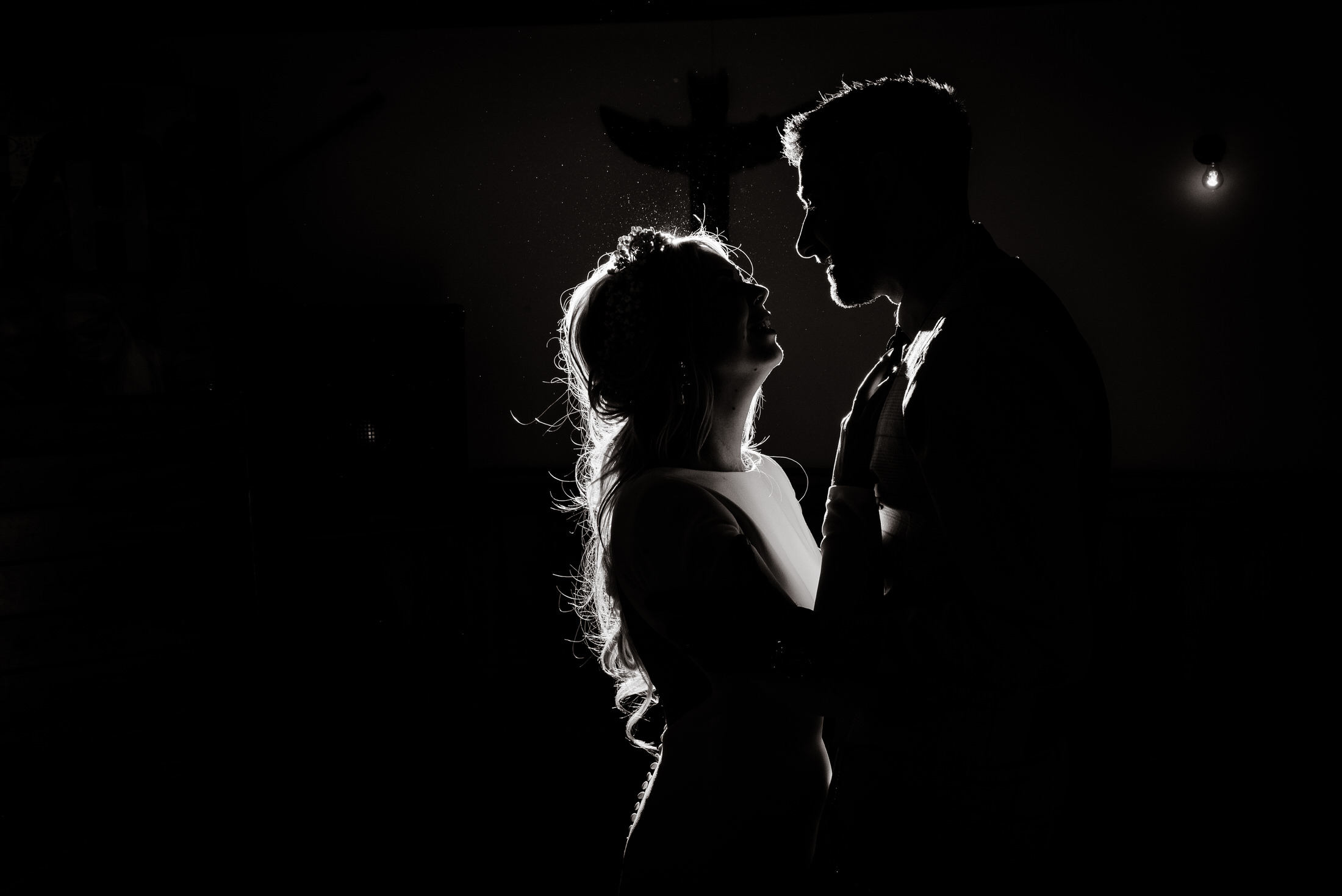 A bride and groom, with the enchanting backdrop of Scrivelsby Walled Garden, embrace in a romantic silhouette on their wedding day.