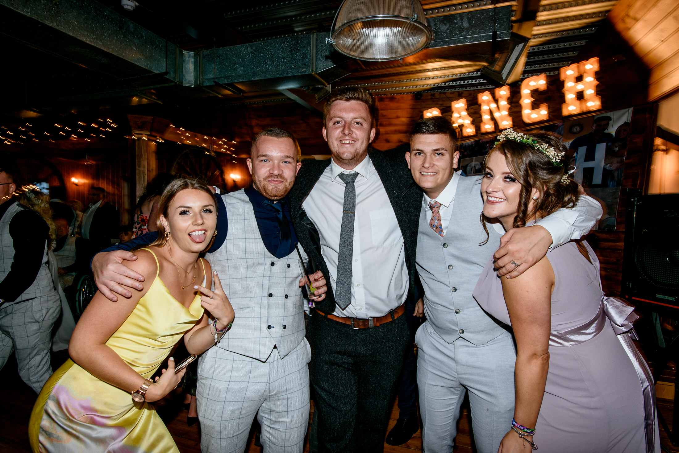 A group of people posing for a photo at a wedding party in the Scrivelsby Walled Garden.