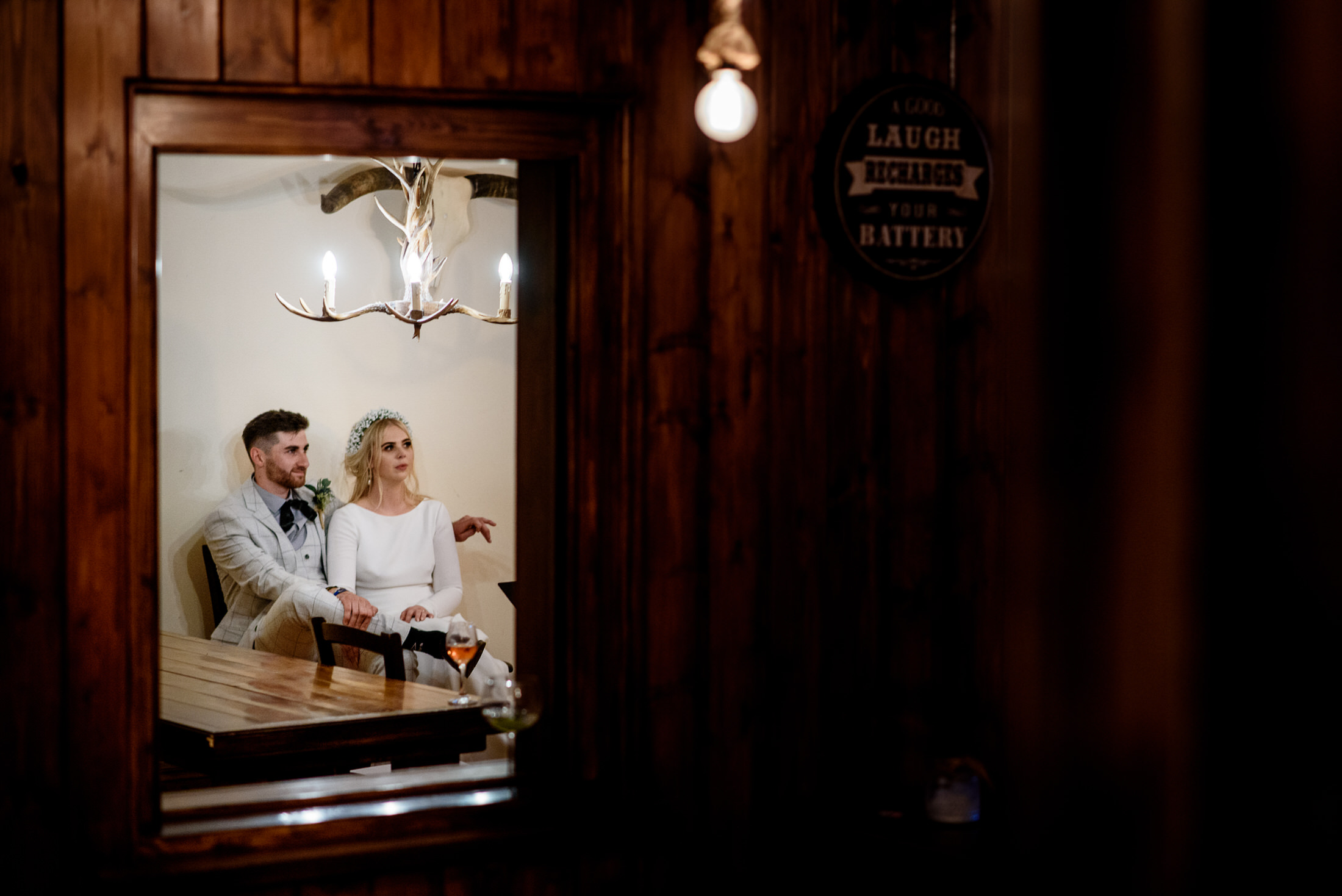 A bride and groom standing in front of a mirror at their wedding in the Scrivelsby Walled Garden.